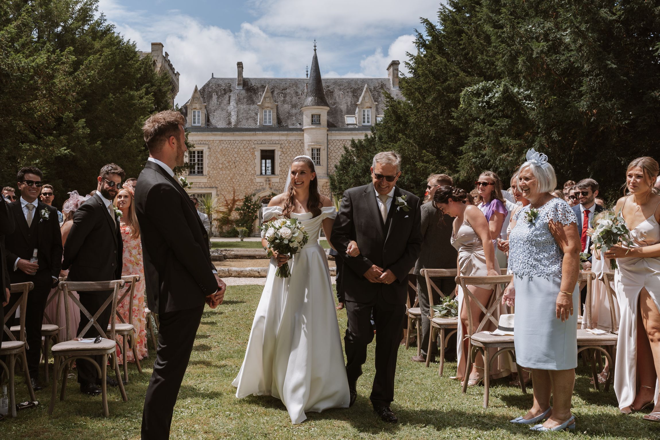 Rebecca and Toby standing together at the aisle, during their wedding ceremony at Château de la Couronne in Southwestern France.