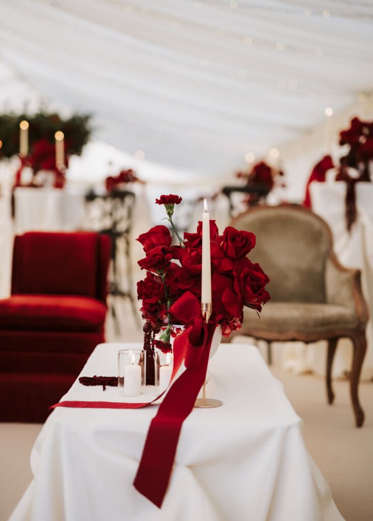 Reception details by Sarah Louisde Planner, red roses laid out decoratively in a marquee wedding