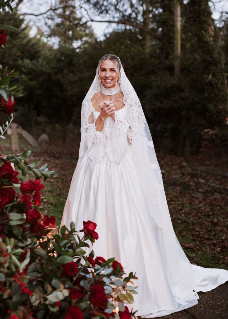 Bride standing eagerly outside the church ready to get married in All Saints Church Essex